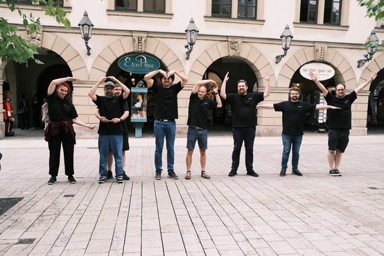 Das Computy-Team formt mit den Armen Buchstaben vor den Arkaden in der Altstadt