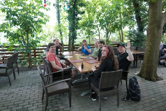 Computy-Mitarbeiter sitzen draußen in einem Restaurant an einem großen Tisch zusammen.