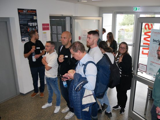 Ankommen beim AI Camp Würzburg: Teilnehmende im Eingangsbereich
